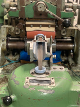 Load image into Gallery viewer, The front end of the pin drafter: qiviut roving emerging from the machine and travelling into the coiling compartment.